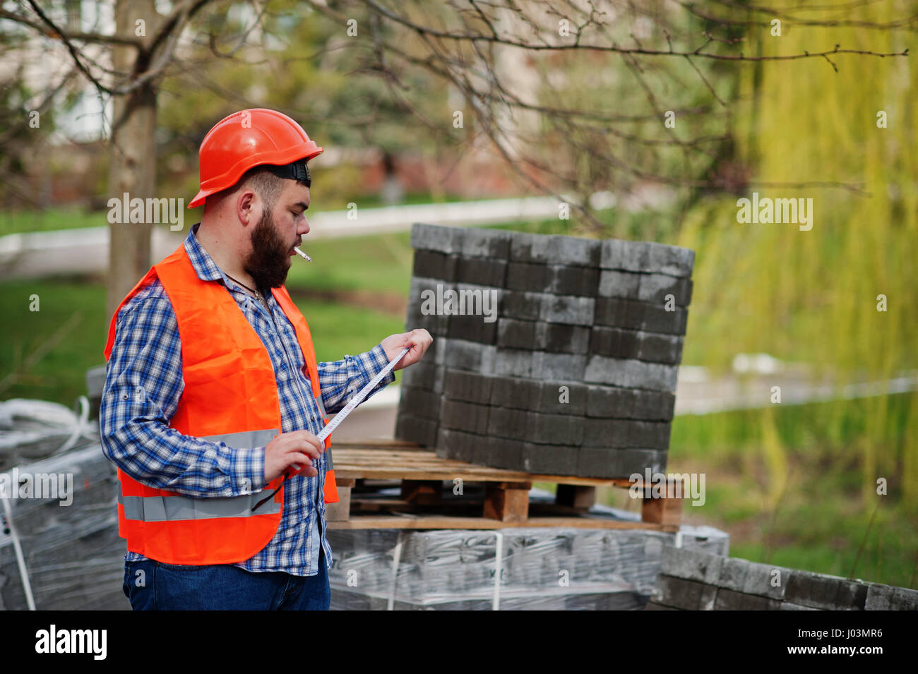 Brutal beard smoking worker man suit construction worker in safety