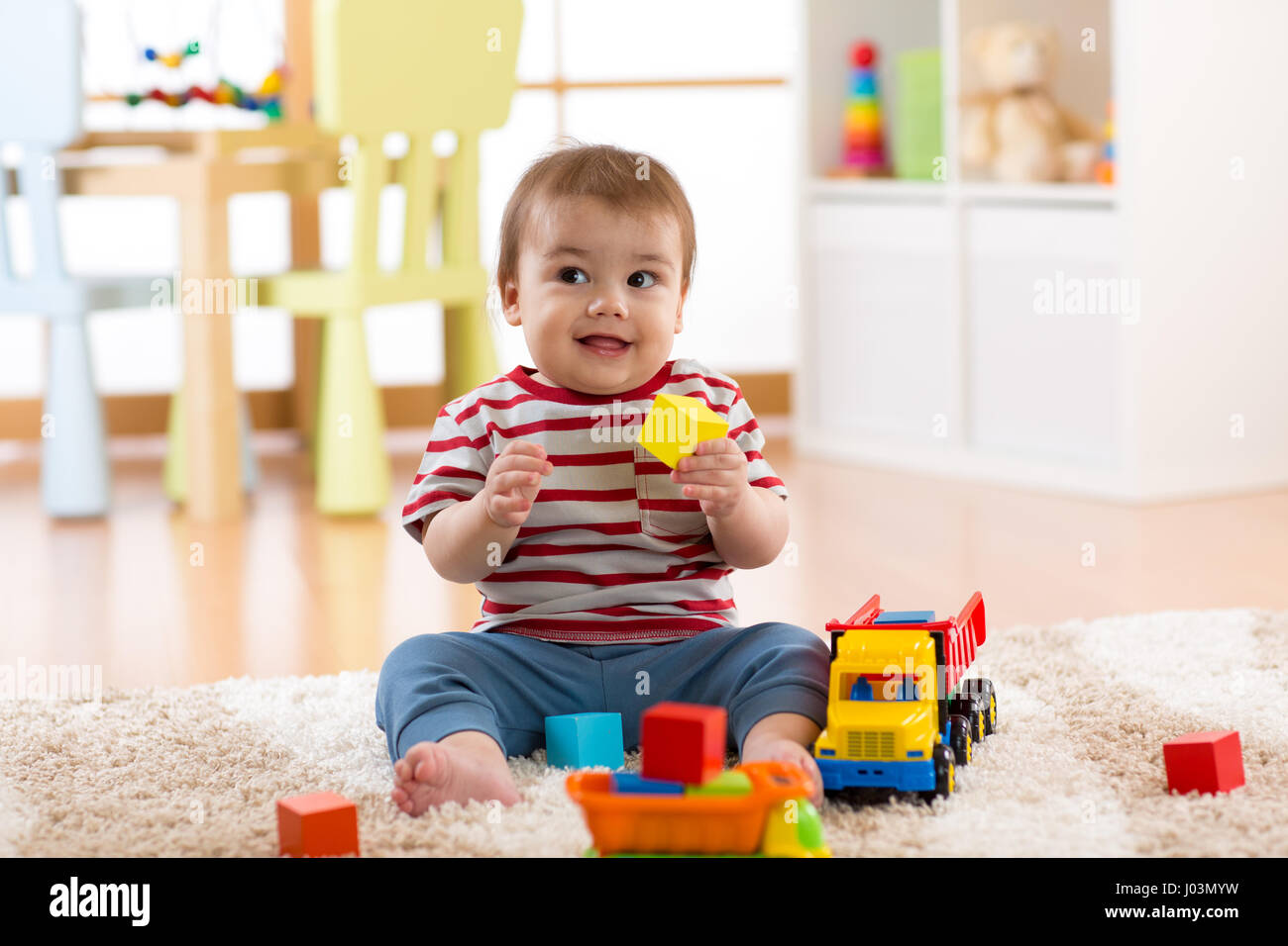 kid boy toddler playing with toy car indoors Stock Photo