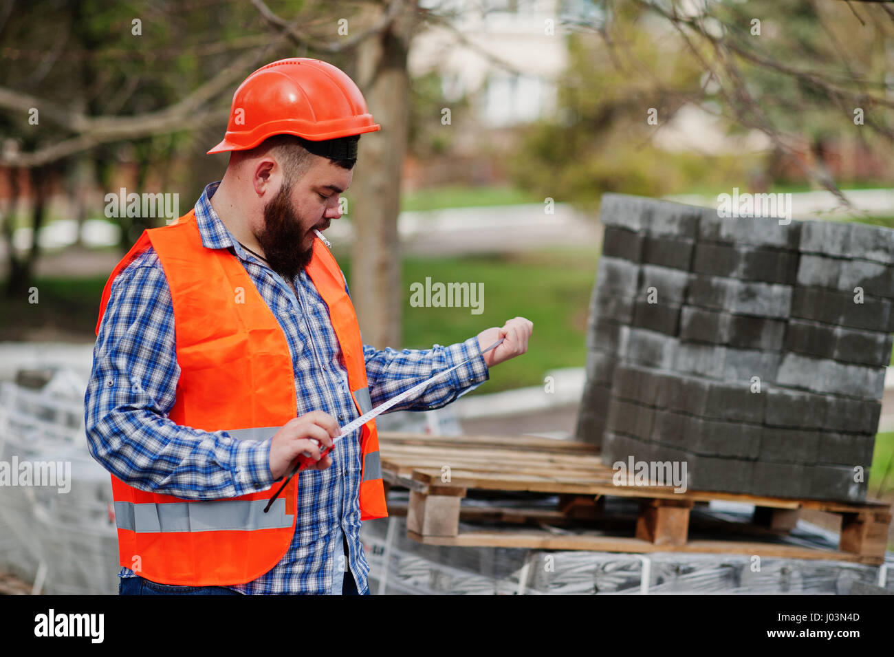 Brutal beard smoking worker man suit construction worker in safety
