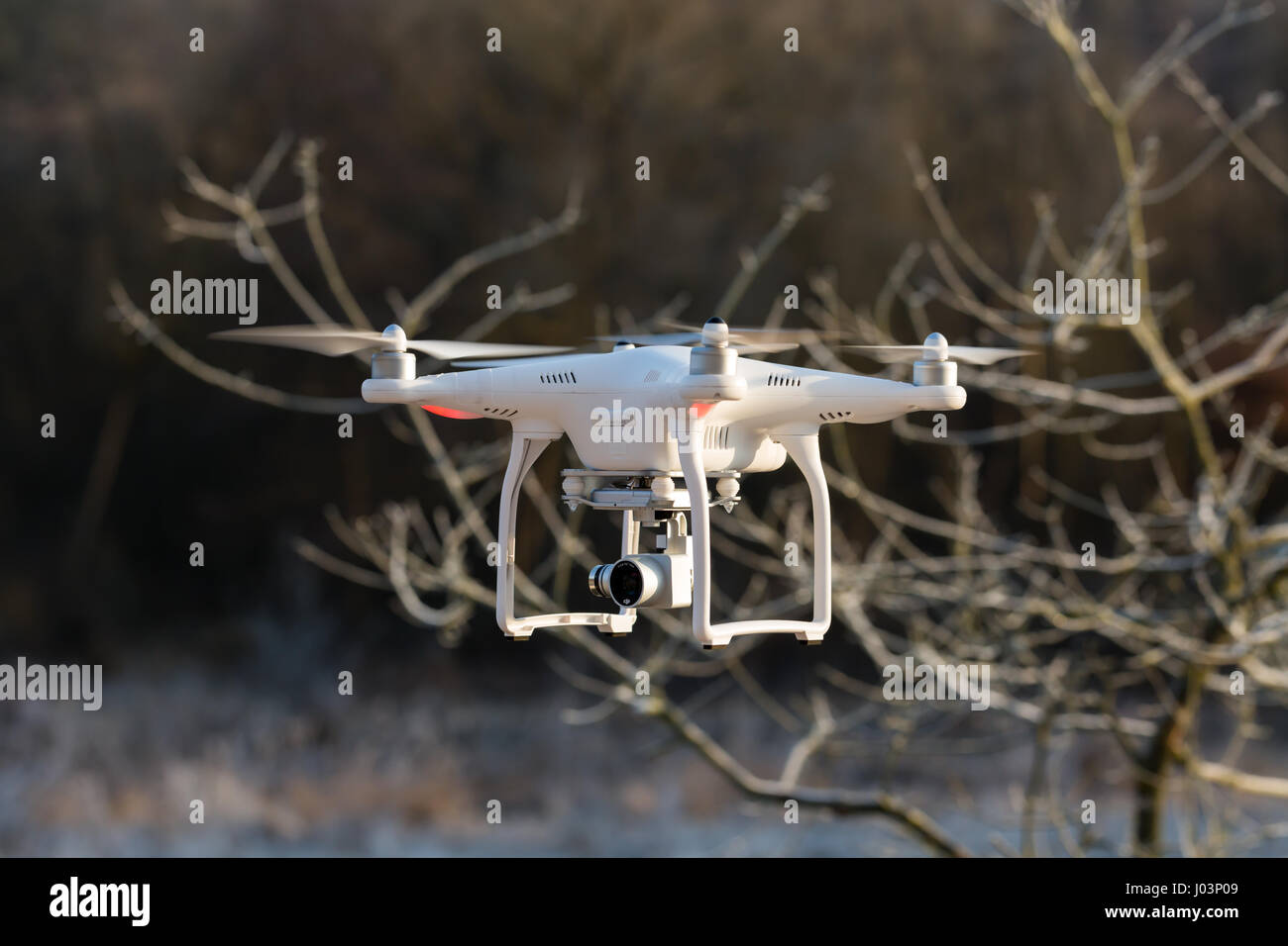 Niedernhausen, Germany - February 25, 2017: DJI Phantom 3 Standard Quadcopter flying in front of wintry vegetation, front view, closeup Stock Photo