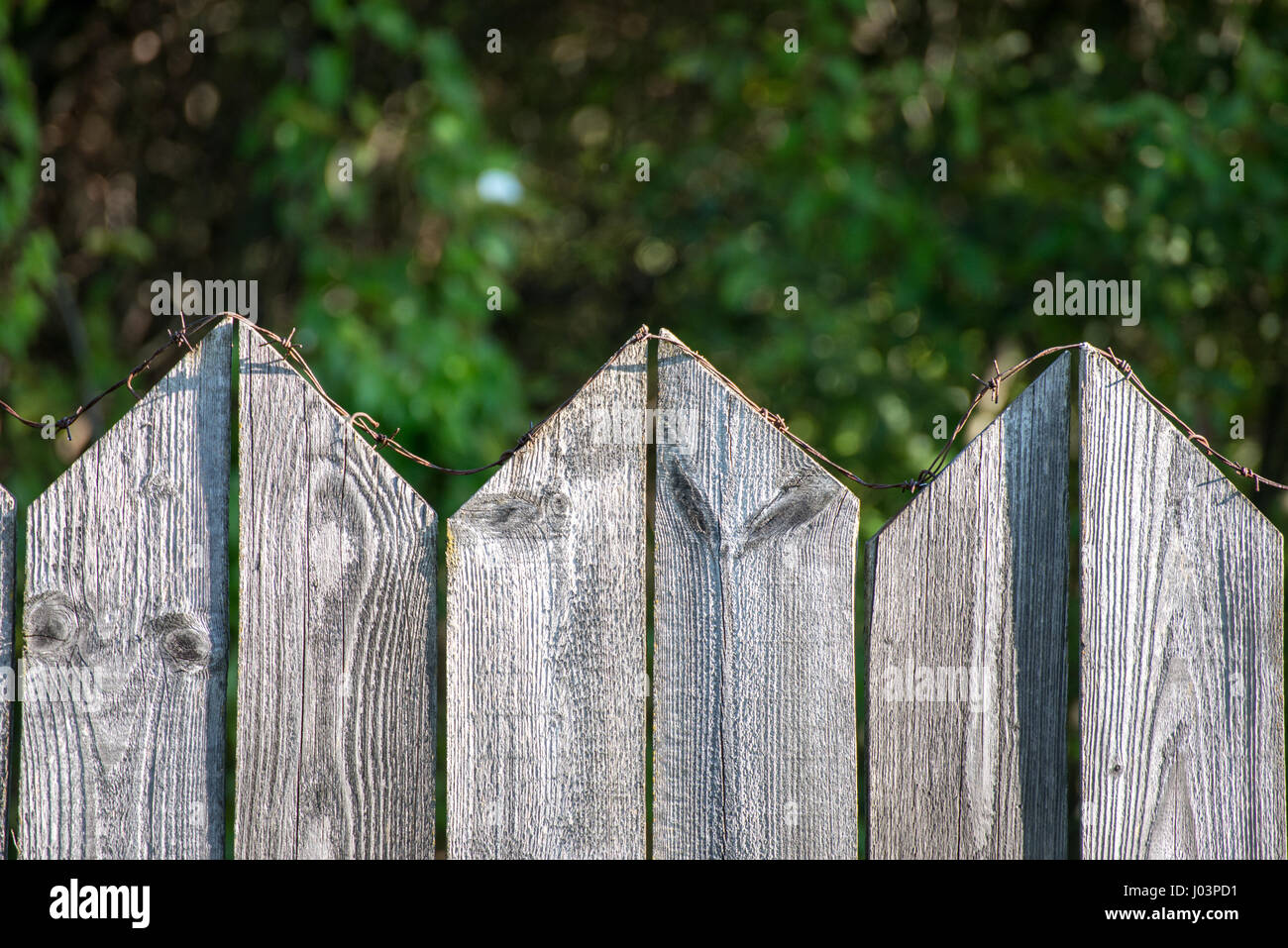 old wooden fence with barbed wire on top Stock Photo - Alamy