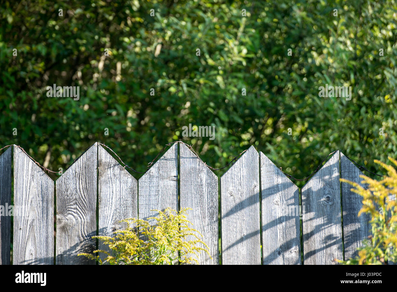 old wooden fence with barbed wire on top Stock Photo - Alamy