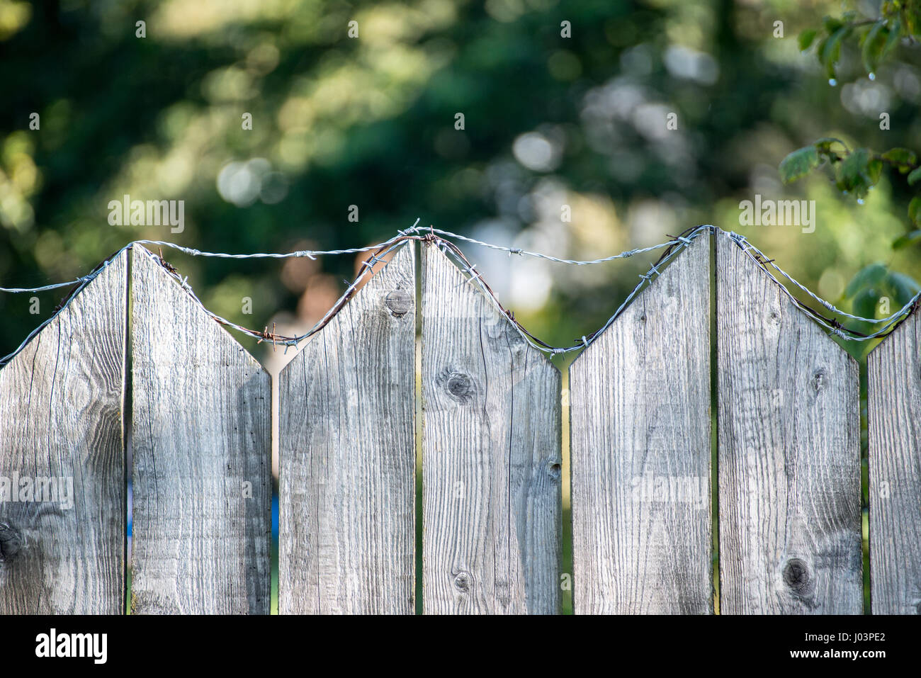 old wooden fence with barbed wire on top Stock Photo - Alamy