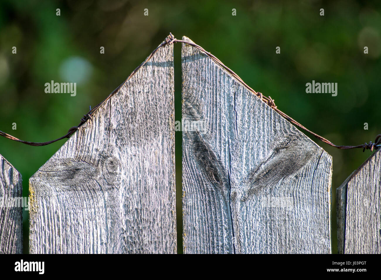 old wooden fence with barbed wire on top Stock Photo - Alamy