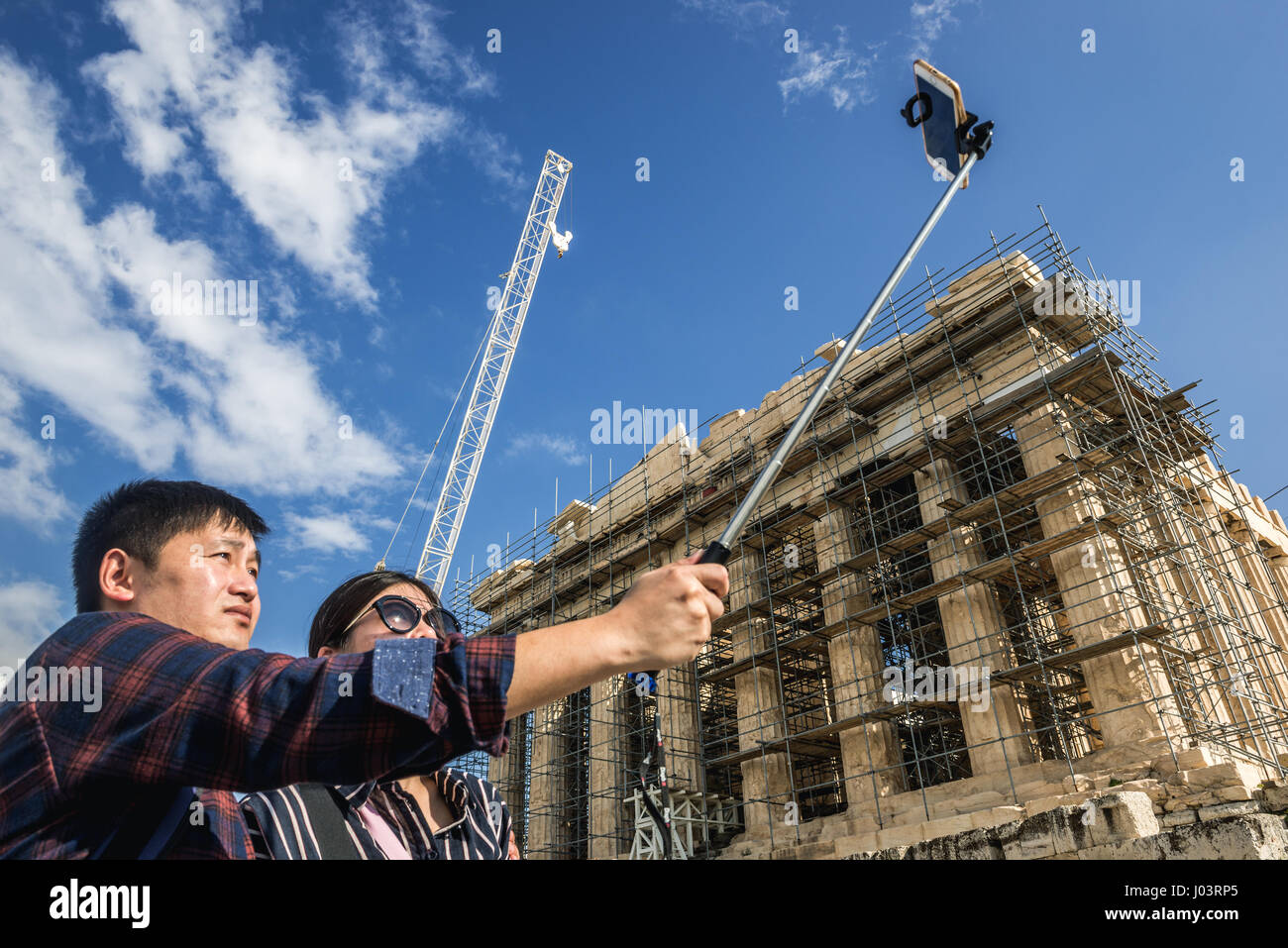 Asian tourists with selfie stick in front of Parthenon temple dedicated to  the goddess Athena, part of Acropolis of Athens city, Greece Stock Photo -  Alamy
