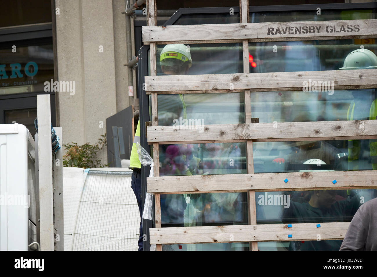 workmen delivering glass panels to commercial development city centre Liverpool UK Stock Photo