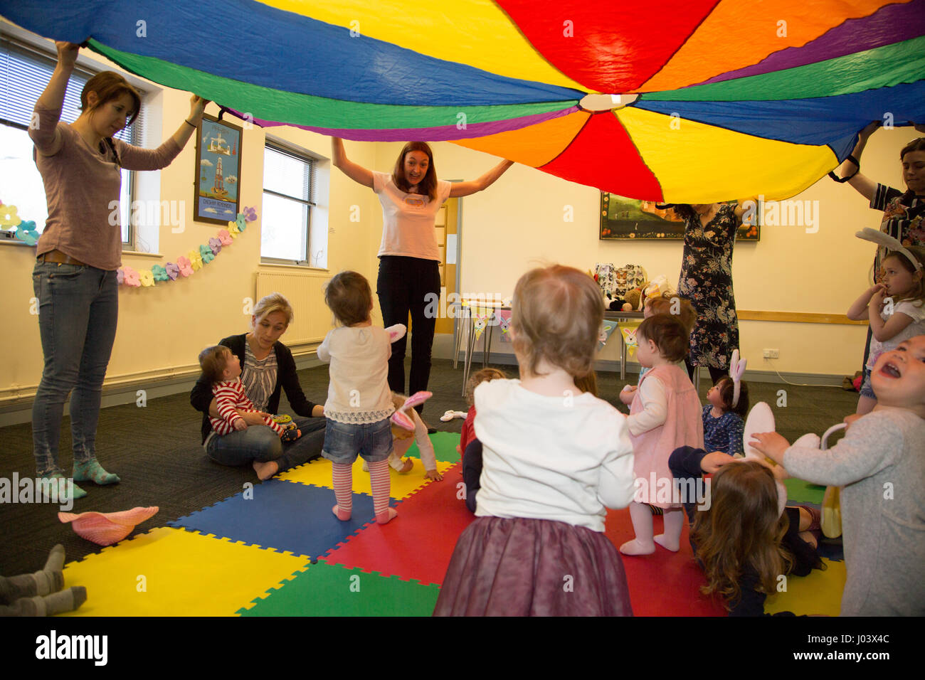 Mother & baby group playing parachute games Stock Photo Alamy
