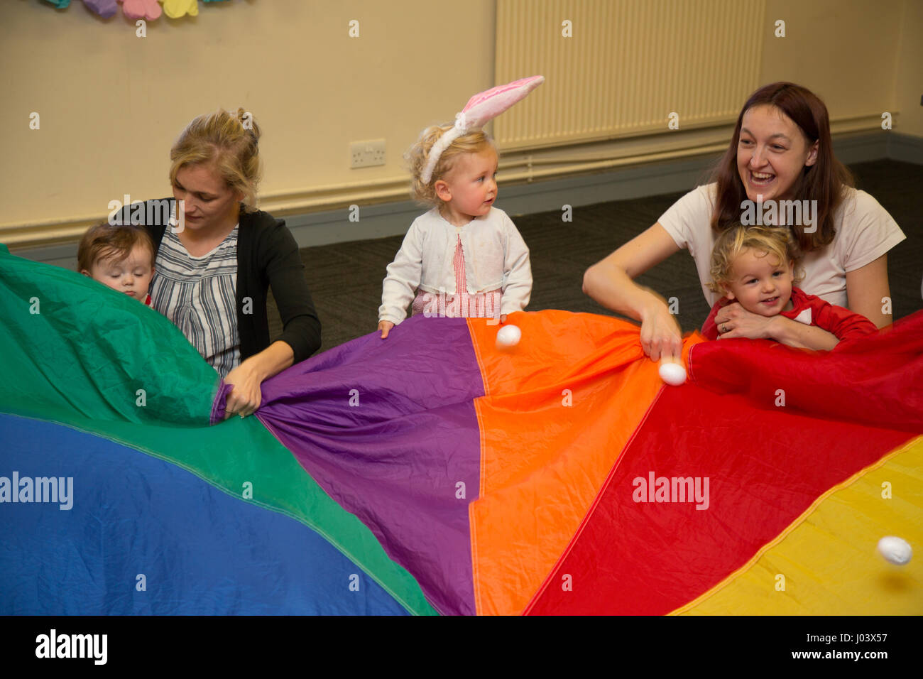 Mother & baby group playing parachute games Stock Photo Alamy