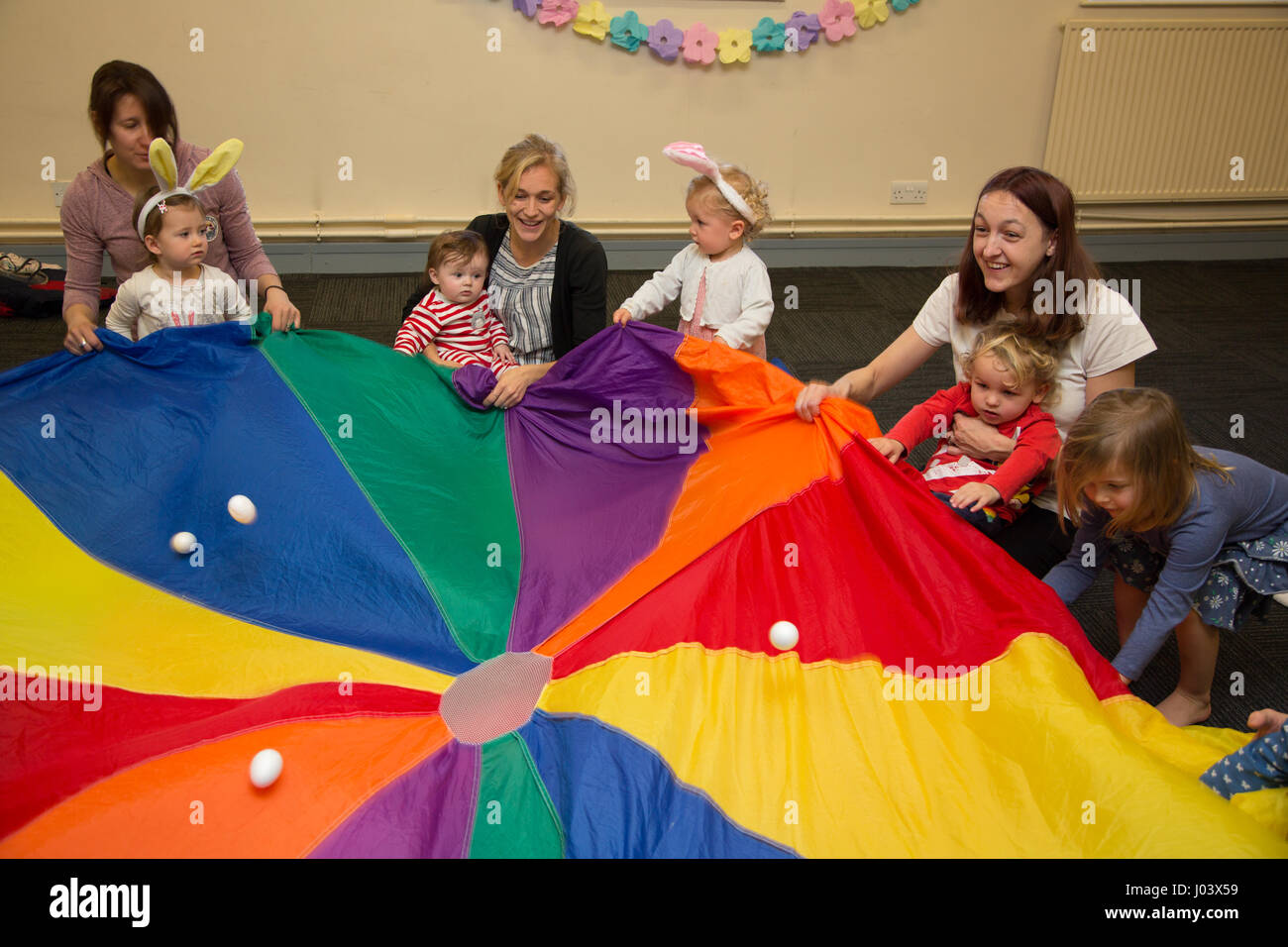 Mother & baby group playing parachute games Stock Photo Alamy