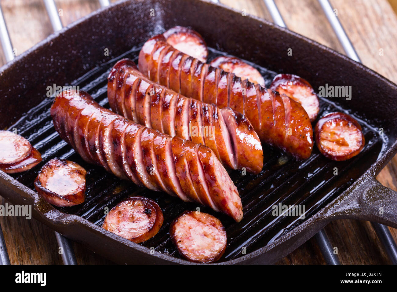 Polish traditional sausages fried on a cast iron skillet. Stock Photo
