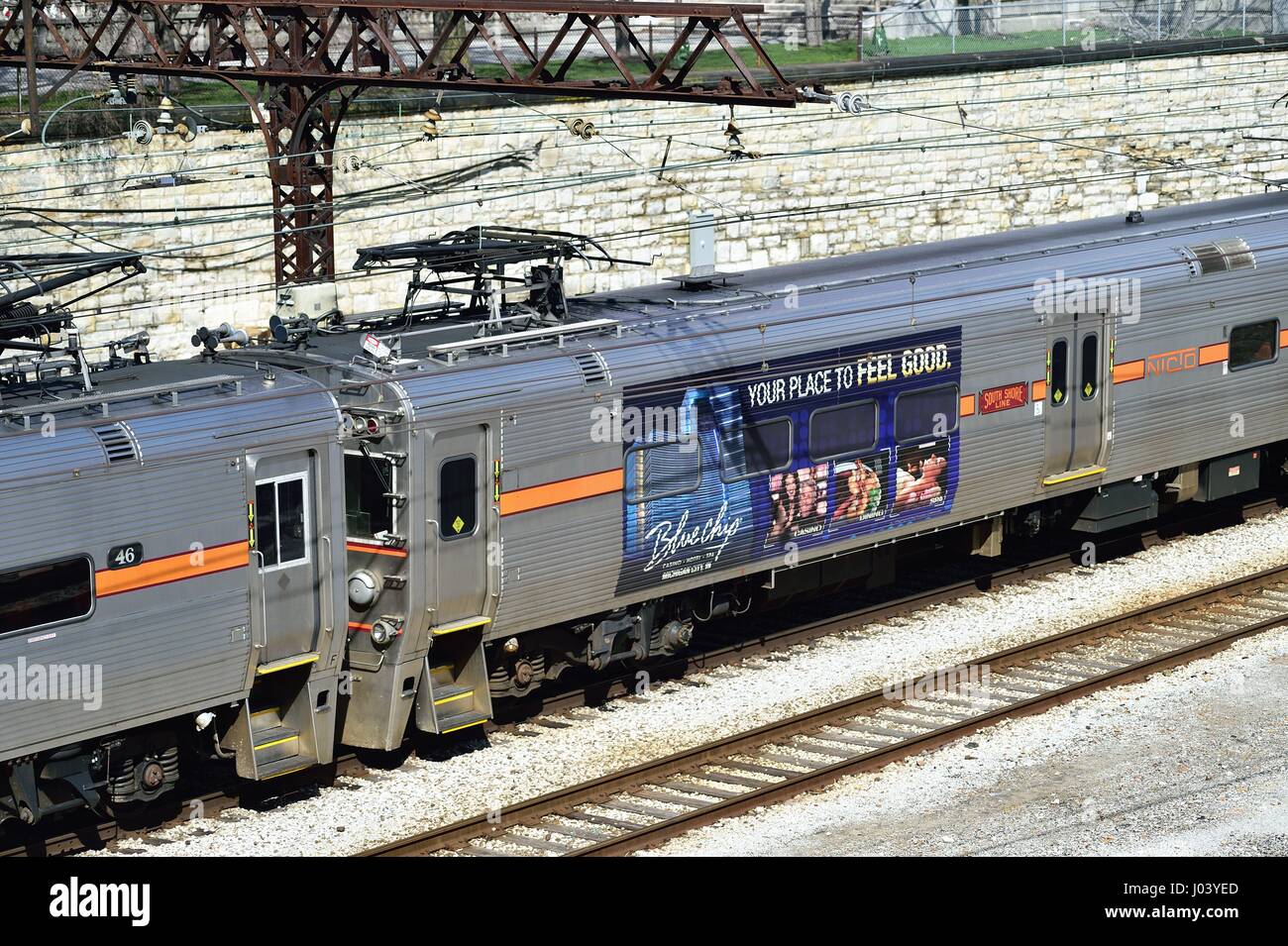 A South Shore Line commuter train sporting advertising arriving on