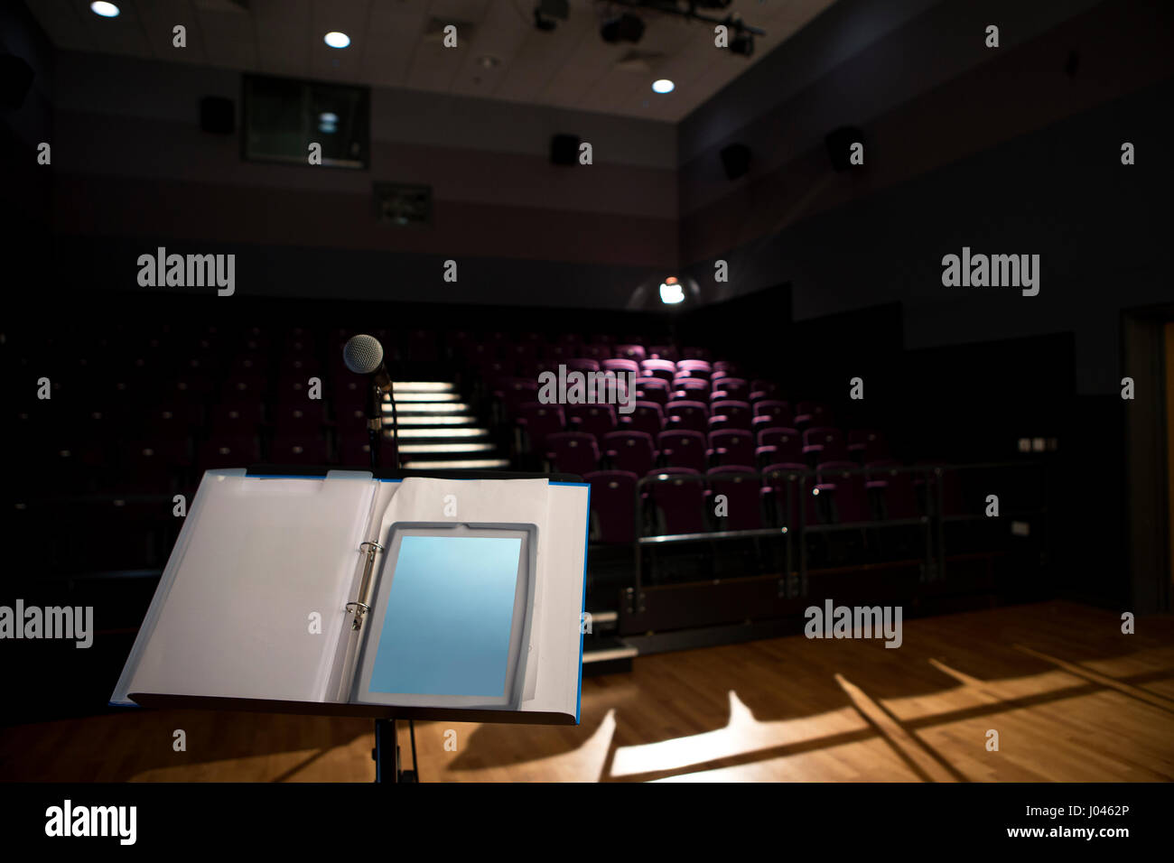 Empty lecture hall with a digital tablet on the podium. Stock Photo