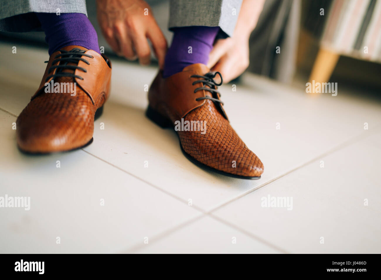 The man in gray slacks and a purple dress socks brown shoes with laces  sitting on the couch Stock Photo - Alamy