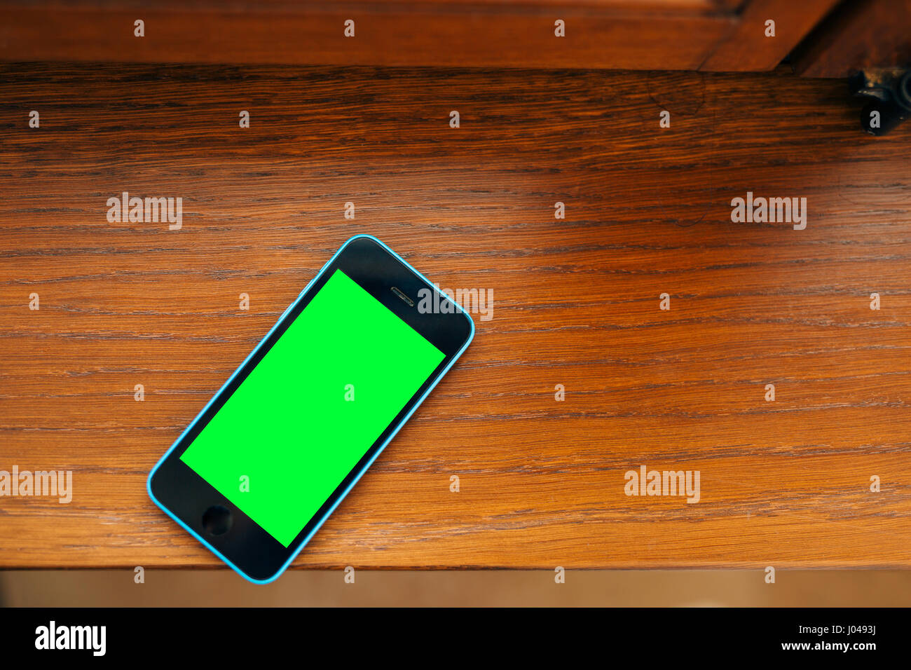 Black and blue phone on the table with green screen Stock Photo Alamy