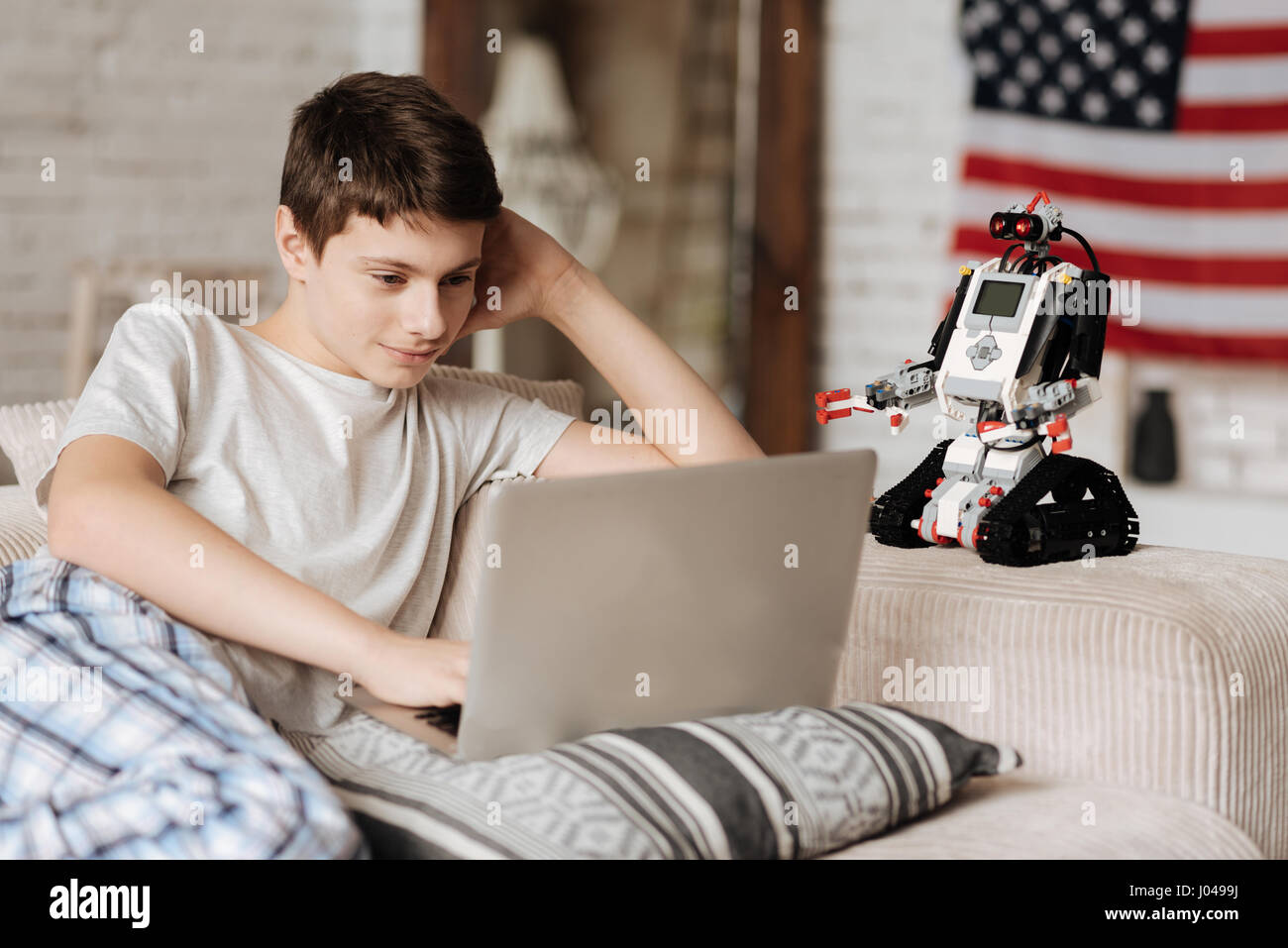 It is exiting. Little nice boy smiling while looking at computer ...
