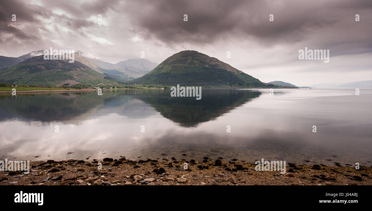 The Ballachulish Bridge and hotel are nestled on the shore of Loch Linnhe sea inlet under the steep mountains of the West Highlands of Scotland. Stock Photo