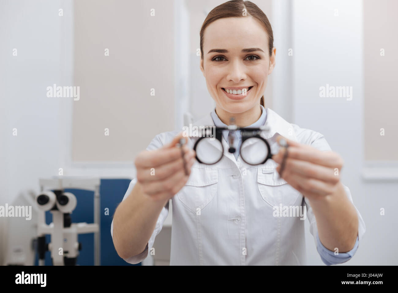 Joyful friendly optometrist offering you eye test glasses Stock Photo