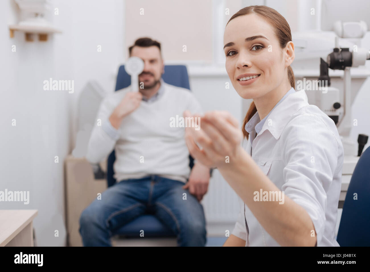 Beautiful attractive doctor working with an eye chart Stock Photo