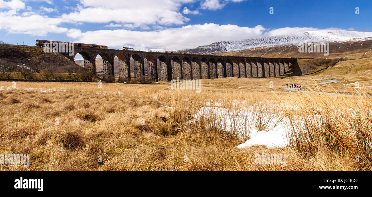 Settle, England, UK - April 1, 2013: A Northen Rail diesel passenger train crosses the landmark Ribblehead Viaduct on the Settle-Carlisle Railway Line Stock Photo