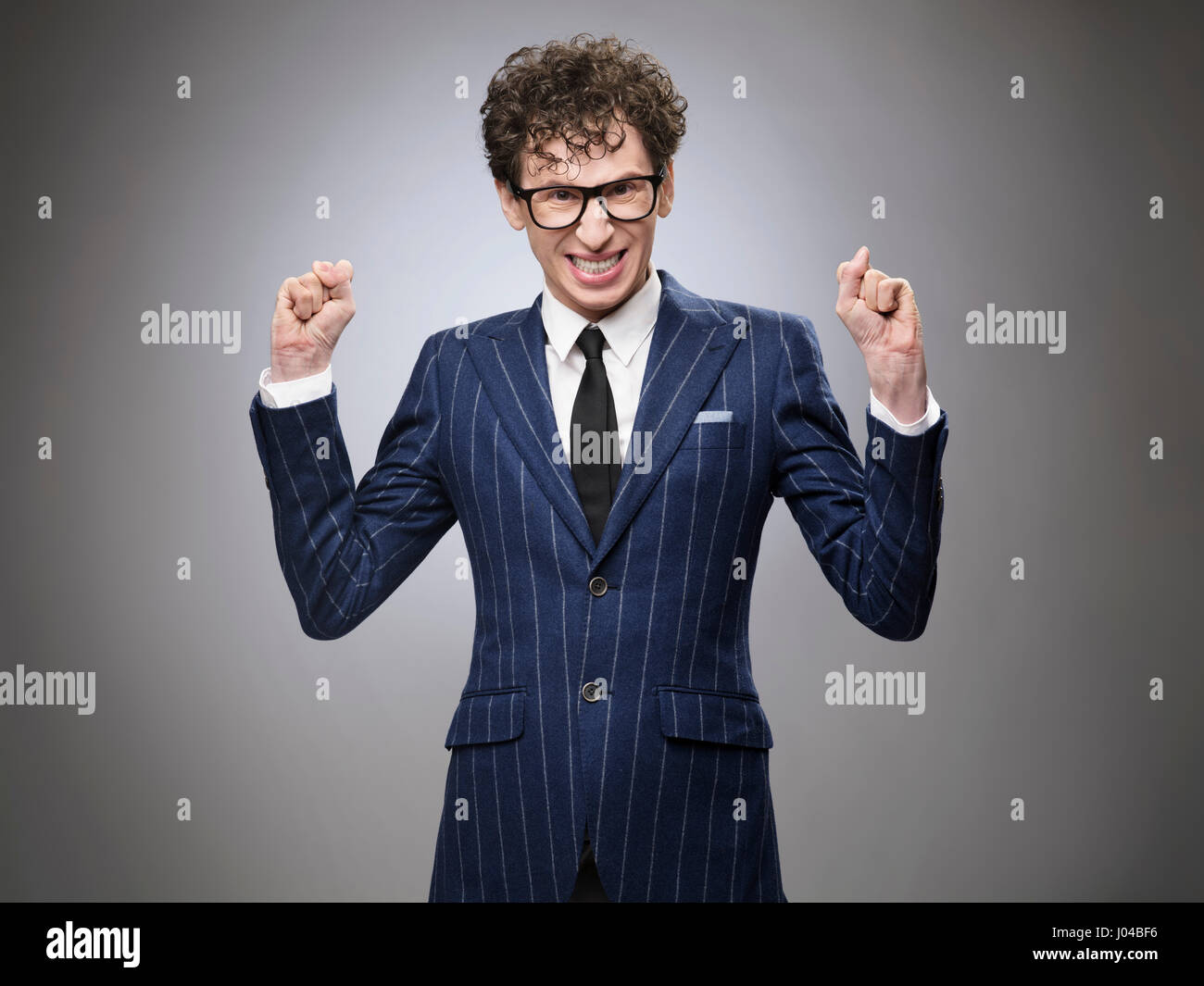 Super excited funny evil genius businessman. Professional actor facial expression. Toothy smiling, clenching fists. Stock Photo