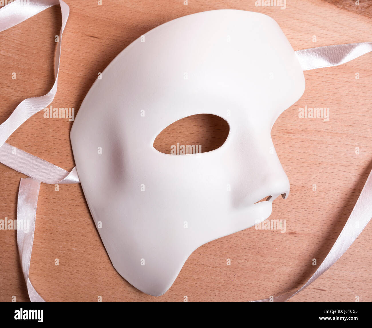 White Scary Halloween mask on wooden background. Stock Photo