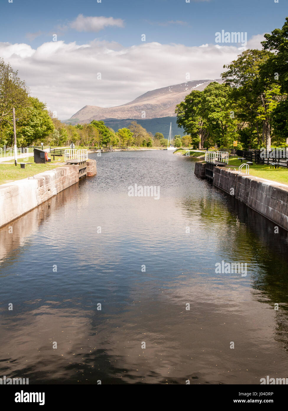 Ben Nevis mountain rises in the distance behind the Caledonian Canal at