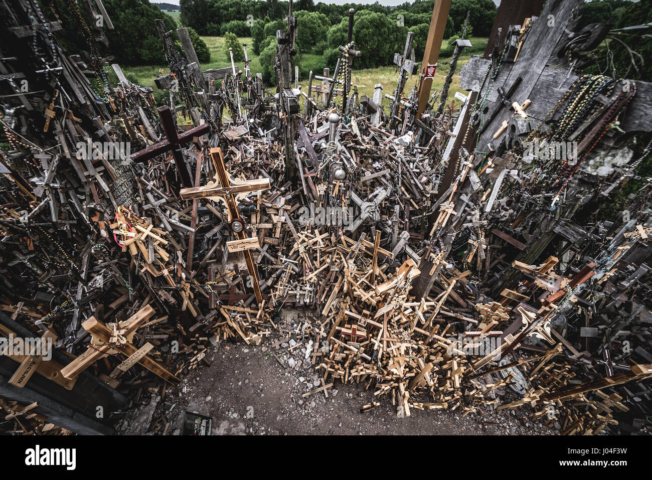 Heap of small crosses brought by pilgrims on Hill of Crosses in Lithuania Stock Photo