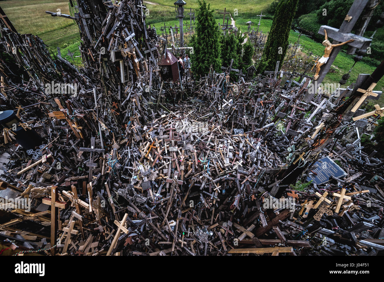 Heap of small crosses brought by pilgrims on Hill of Crosses in Lithuania Stock Photo
