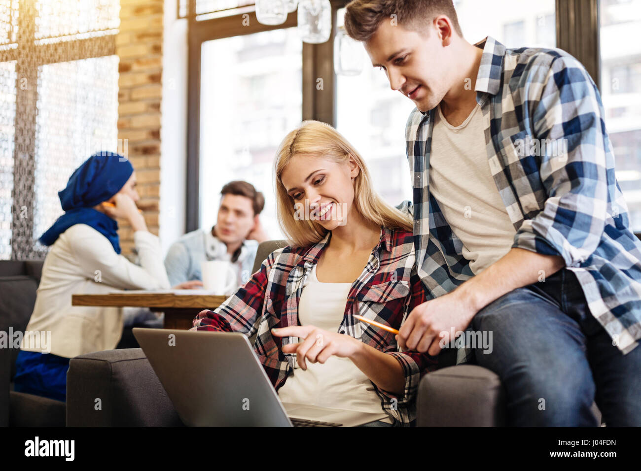 Positive Rested Students Positive delighted students having rest in the cafe Stock Photo - Alamy