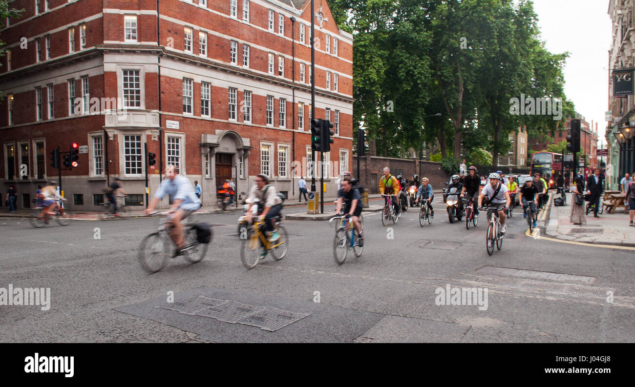 London, England - July 5, 2011: Commuter cyclists set off from a green light at a busy road junction in Central London. Stock Photo