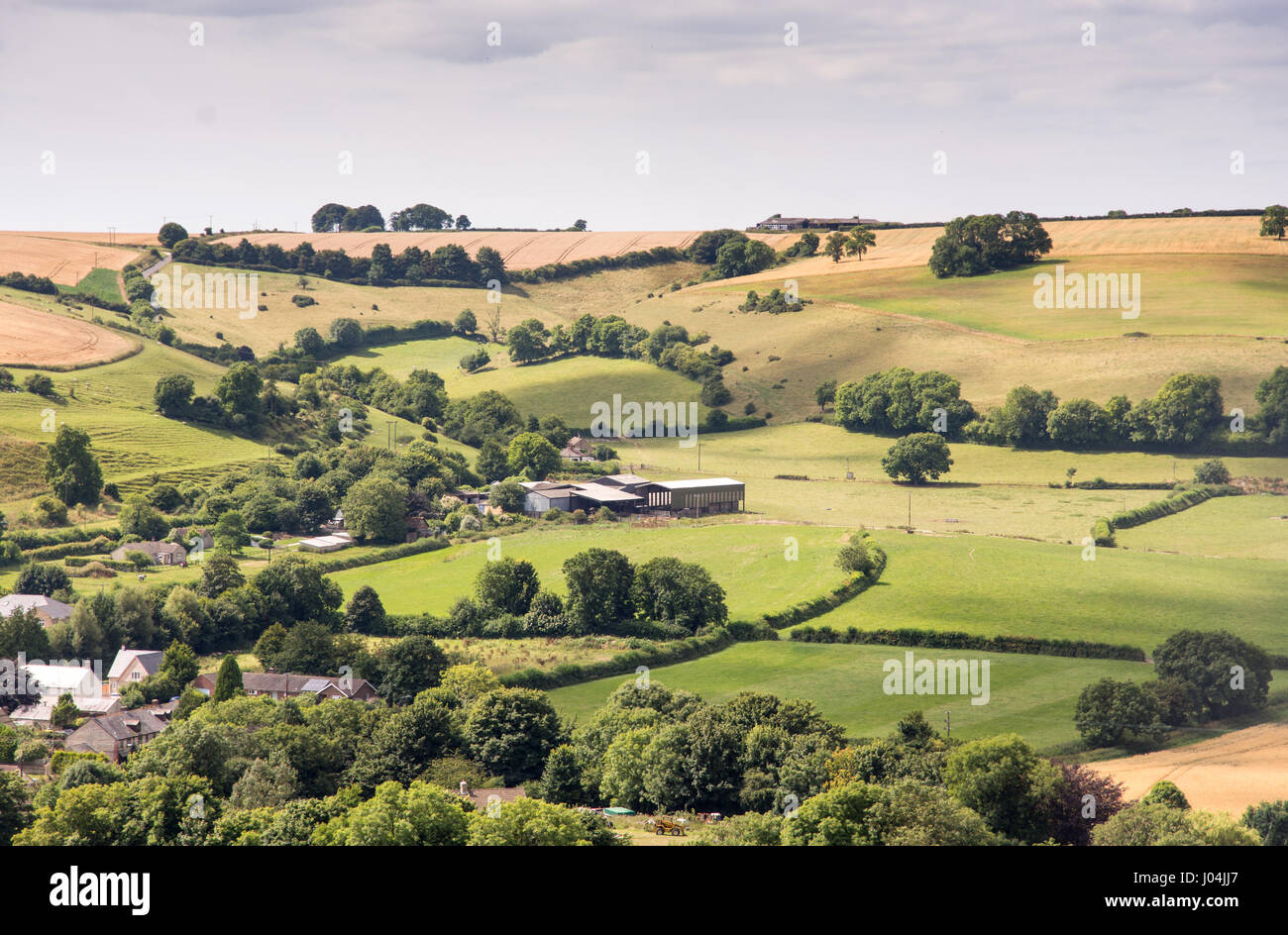 Cerne Abbas nestled amongst fields and pastures in the Cerne Valley under the rolling hills of England's Dorset Downs. Stock Photo