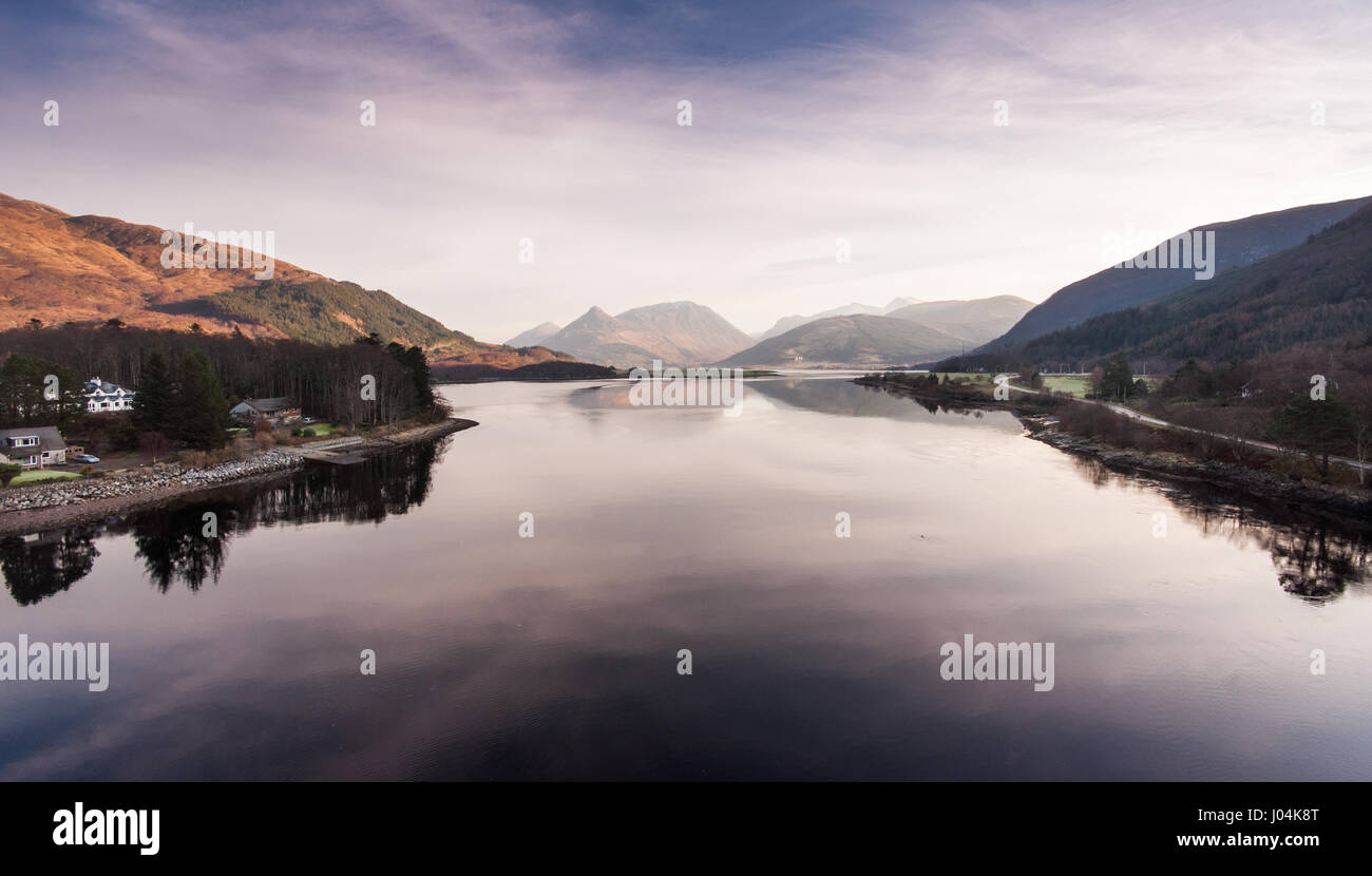 The mountains of Glen Coe reflected in Loch Linnhe sea loch, viewed from the Ballchulish Bridge in the West Highlands of Scotland. Stock Photo