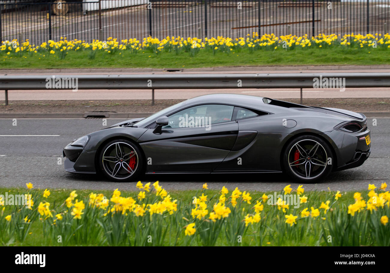 A charcoal grey 3.8-litre mid-mounted V8 engine McLaren 570S super sports car travelling along the Kingsway West dual carriageway in Dundee, UK Stock Photo