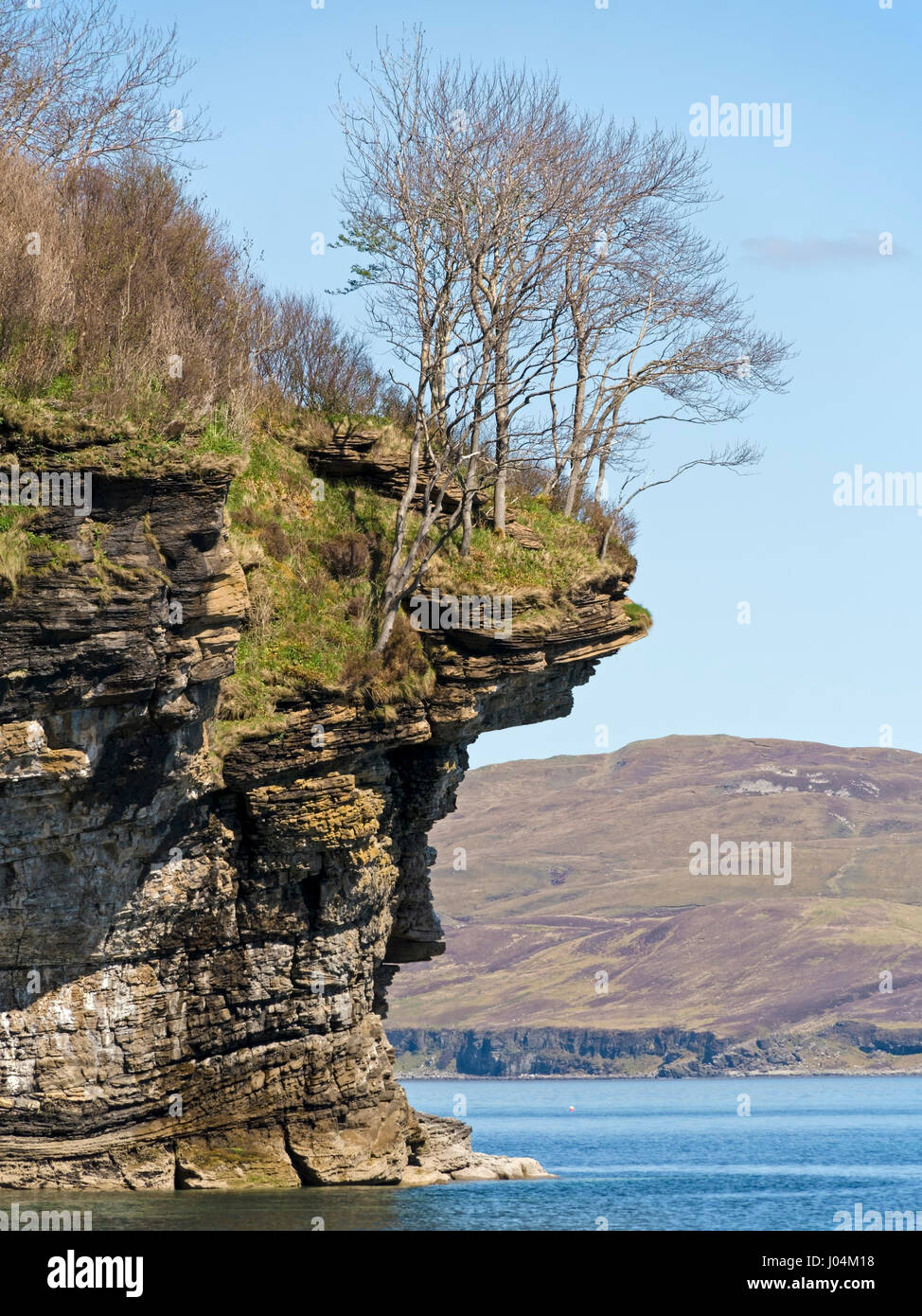 Overhanging sea cliffs and trees at Glasnakille near Elgol on the Isle of Skye, Scotland, UK Stock Photo