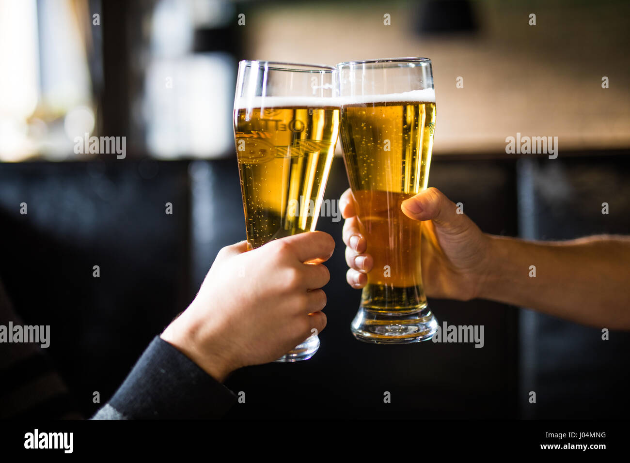 Men cheers with beer in glasses in pub Stock Photo Alamy