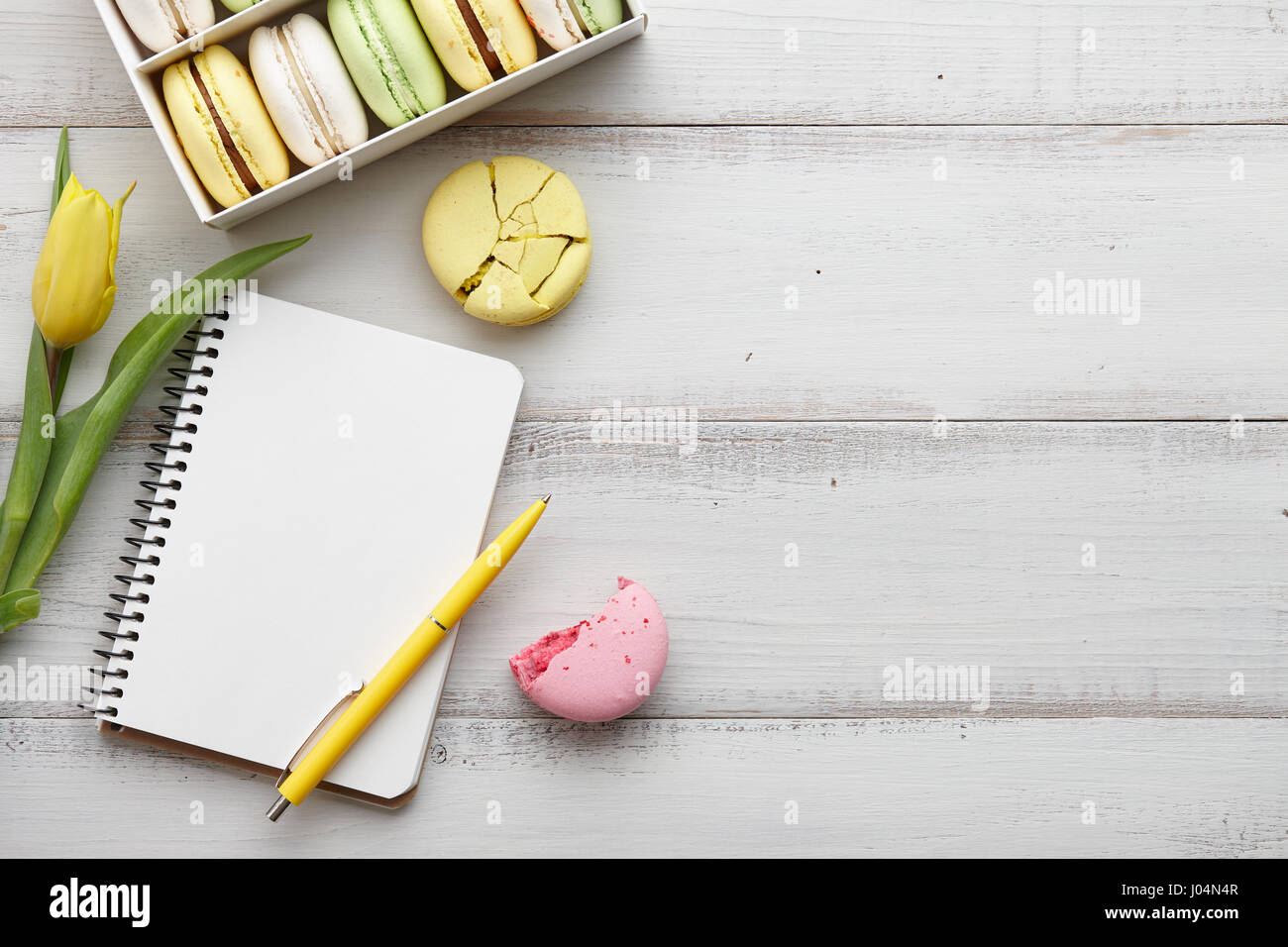 Feminine workspace with macarons and tulips Stock Photo