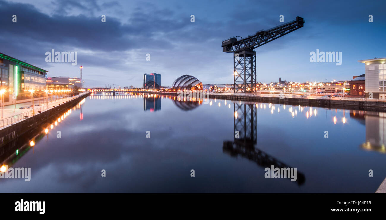Glasgow, Scotland, UK - January 9, 2011: The iconic Finnieston Crane is reflected in the River Clyde at sunset in the former docklands of Glasglow, al Stock Photo