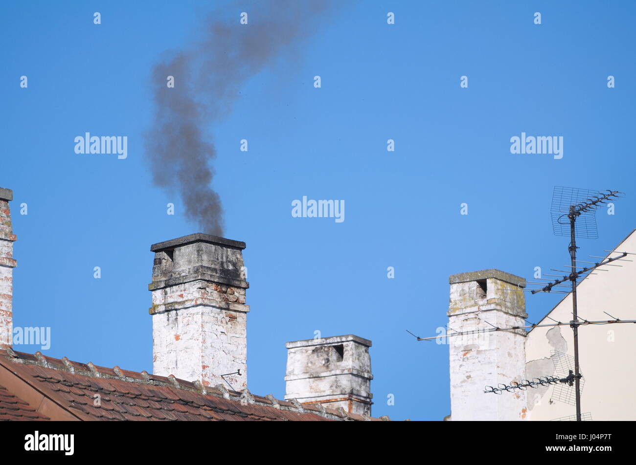 Smoky Residential Chimneys with Clear Blue Sky Stock Photo