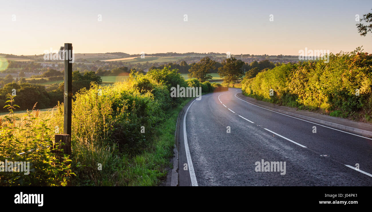 A footpost fingerpost points across a hedge and through farmland fields beside the A352 road near Sherborne in north west Dorset. Stock Photo