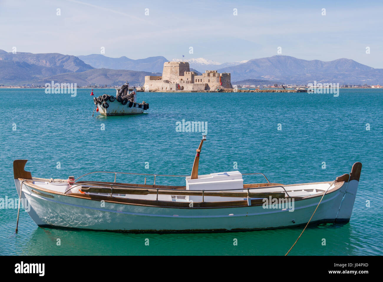Traditional Fishing Boats and Bourtzi Fortress in the background in Nafplion, Greece- landscape photo Stock Photo