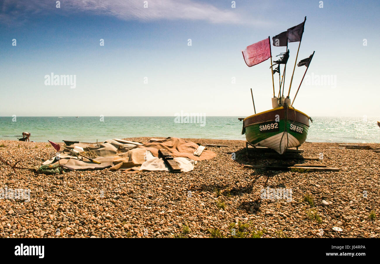 Lancing, England, UK - August 18, 2012: A small traditional wooden fishing boat is beached on the pebbles of Lancing Beach, beside the English Channel Stock Photo