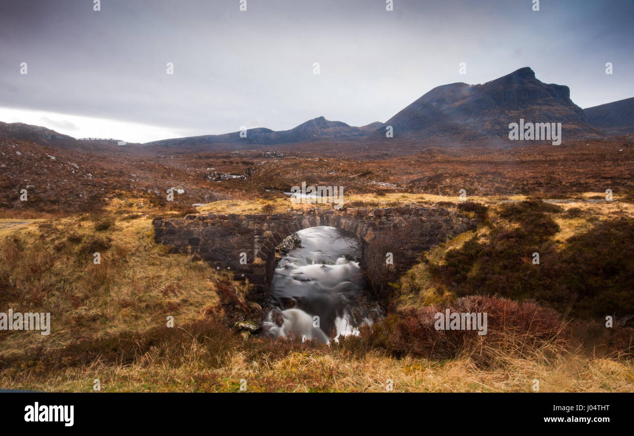 A mountain stream flows in torrents off Quinag mountain near Kylesku in Assynt in the far north west of the Scottish Highlands. The old disused road c Stock Photo