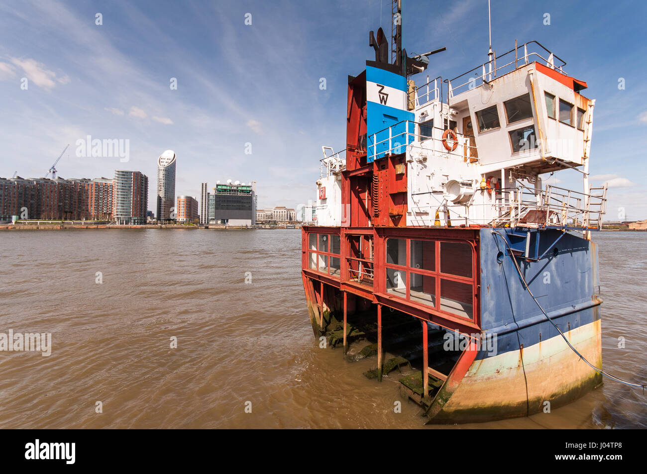 London, England, UK - April 10, 2010: A section of a small cargo boat fixed in the River Thames at North Greenwich, by artist Richard Wilson. Stock Photo