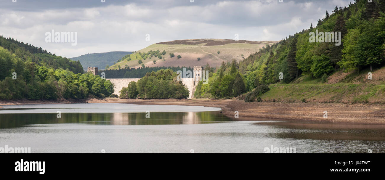 The dam of Howden Reservoir rises from the waters of Derwent Reservoir, part of the string of reservoirs nestled amongst woodland in the Upper Derwent Stock Photo