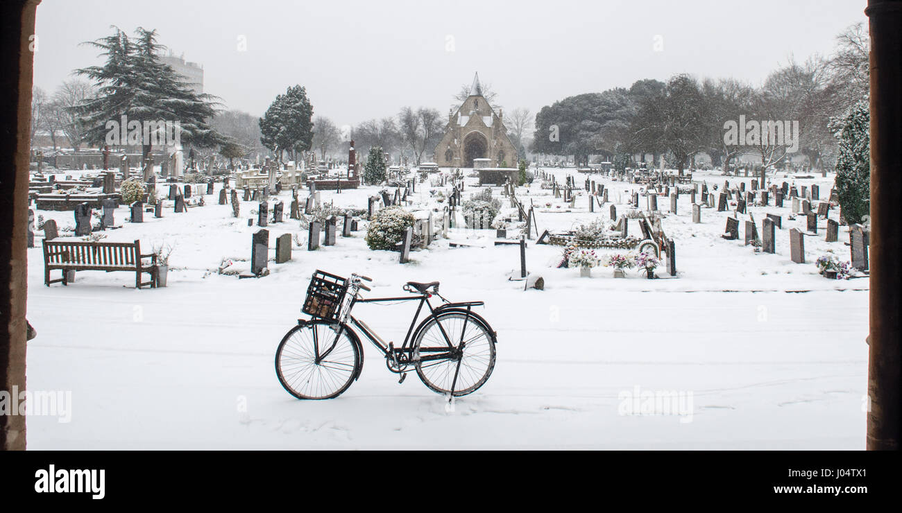A traditional English upright bicycle stands in snow at Lambeth Cemetery in Tooting, south west London. Stock Photo