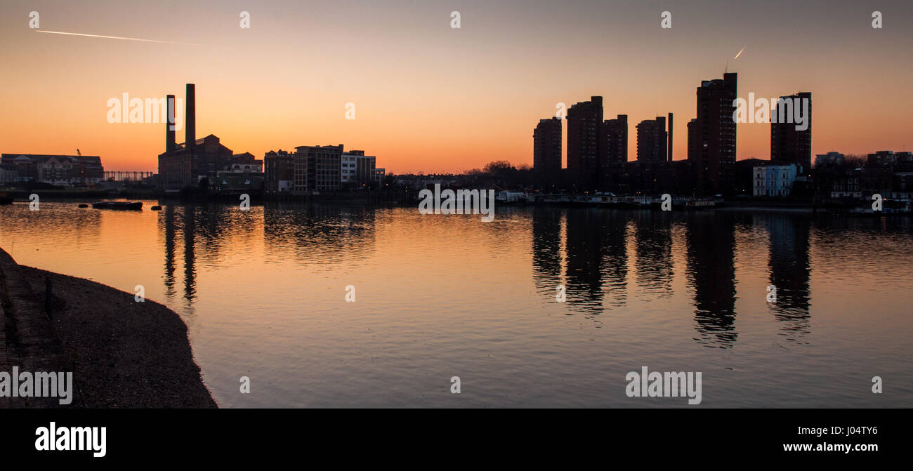 Lots Road Power Station and the World's End high-rise council estate are reflected in the waters of the River Thames at Chelsea in west London. Stock Photo