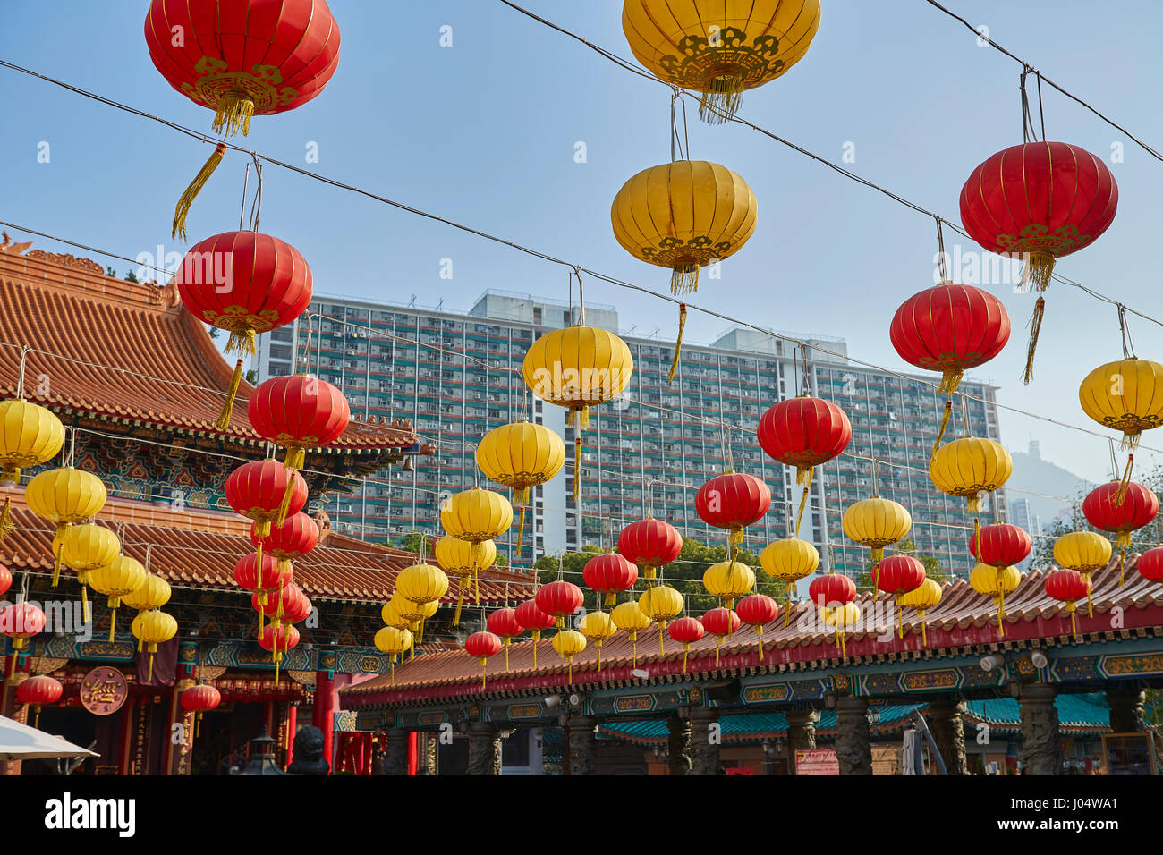 Traditional Chinese Paper Lanterns Contrast With A High Rise Apartment Building At The Wong Tai Sin Temple, Hong Kong. Stock Photo