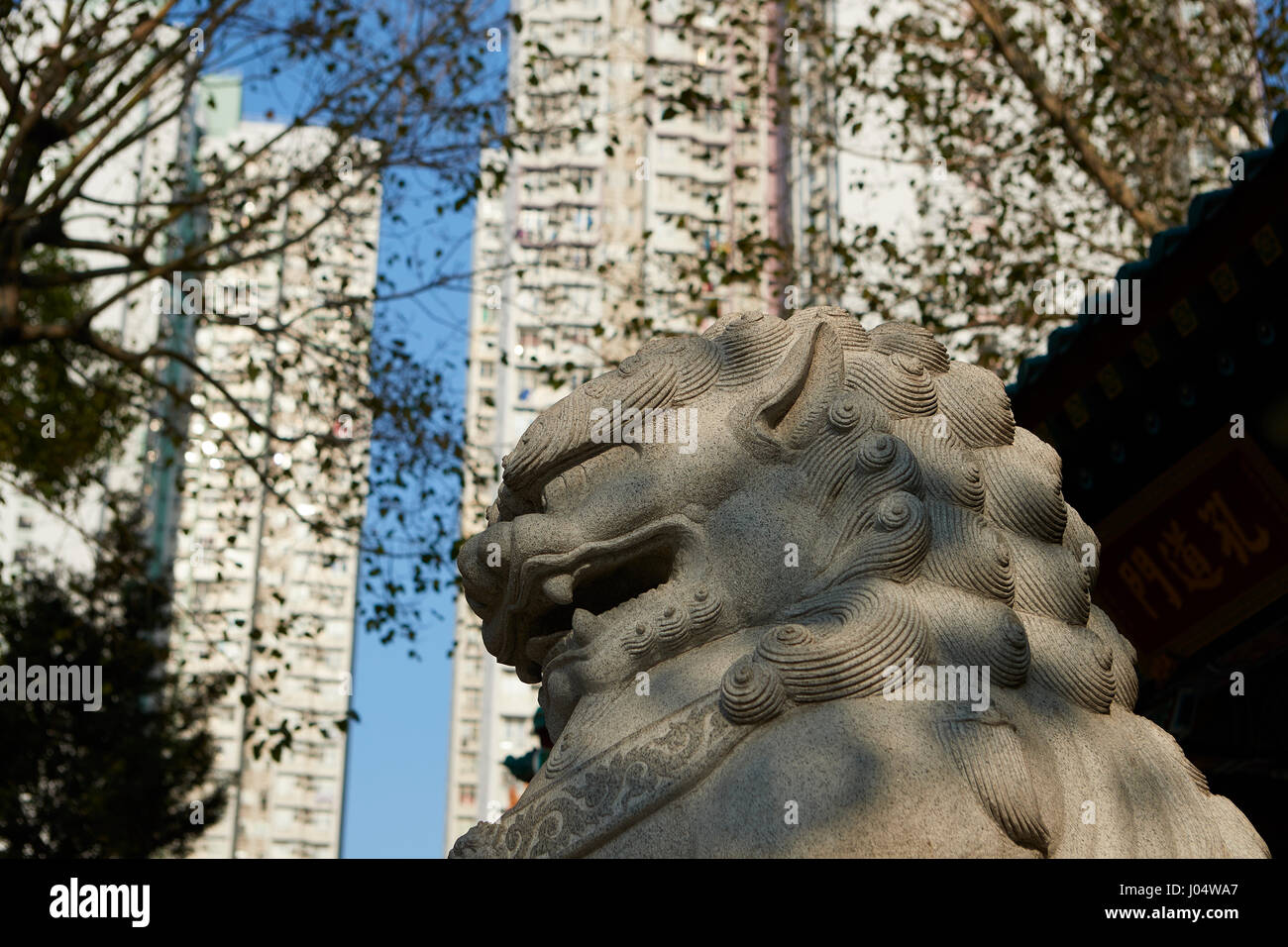 Fierce Chinese Mythical Creature Overlooked By High Rise Apartment Buildings At The Wong Tai Sin Temple, Hong Kong. Stock Photo