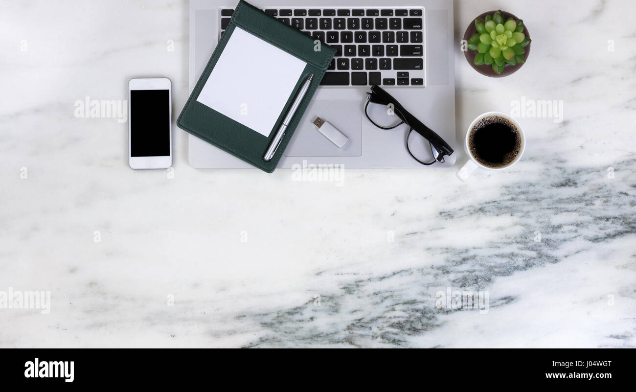 Flat Lay Of A Partial Laptop Plant Smartphone Pen Paper