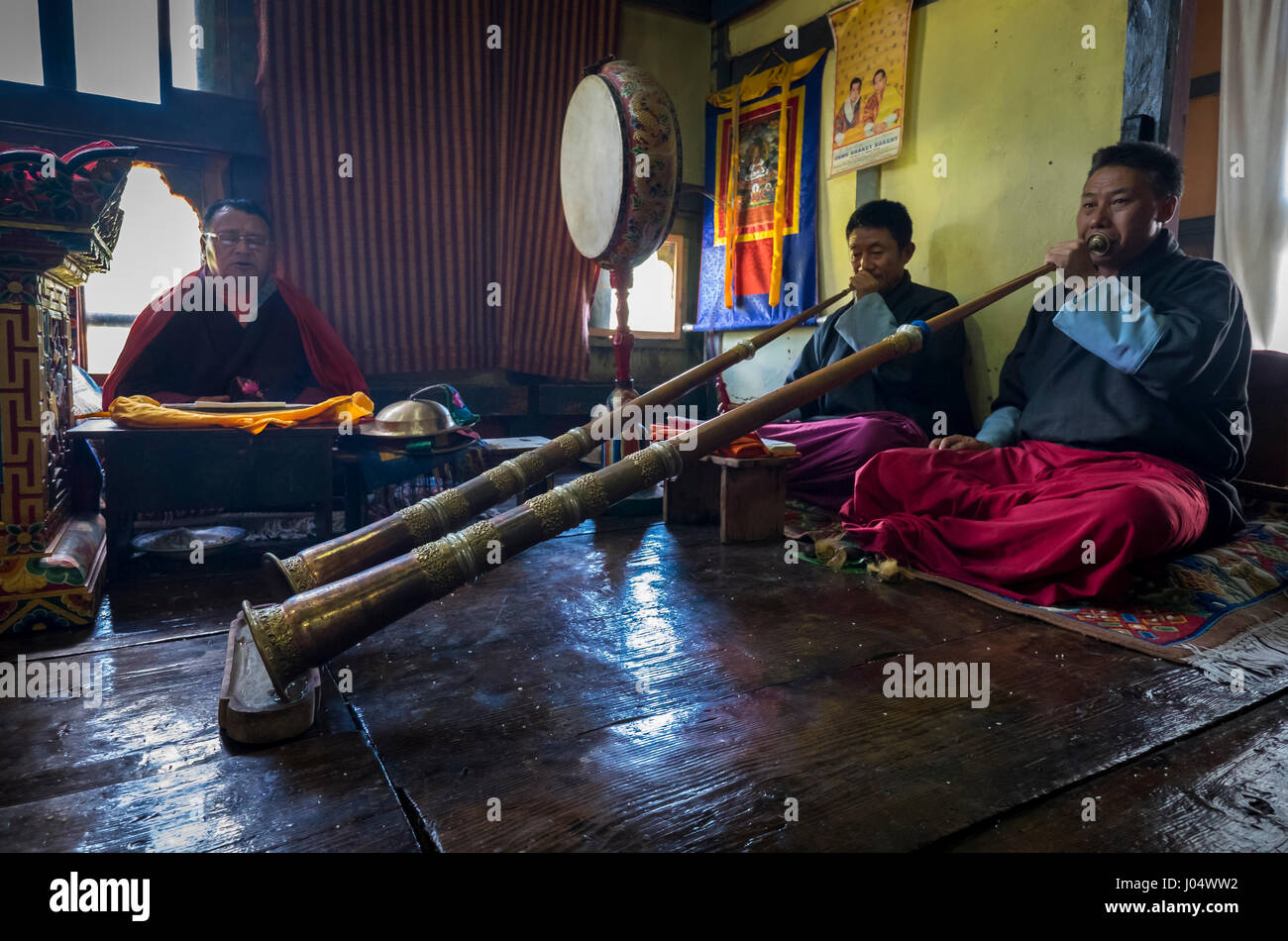 PARO, BHUTAN - CIRCA OCTOBER 2014: Bhutanese men chanting and playing Tibetan trumpets during a ritual in Paro, Bhutan Stock Photo
